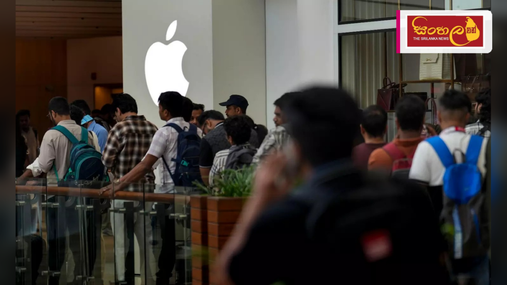 Headline: iPhone 18 උන්මාදය: ඉන්දියාවේ දිගු පෝලිම් සහ මූල්‍ය අවදානම් පිළිබඳ අනතුරු ඇඟවීම් Intended image subject: Customers waiting in a long queue outside an Apple Store in India
